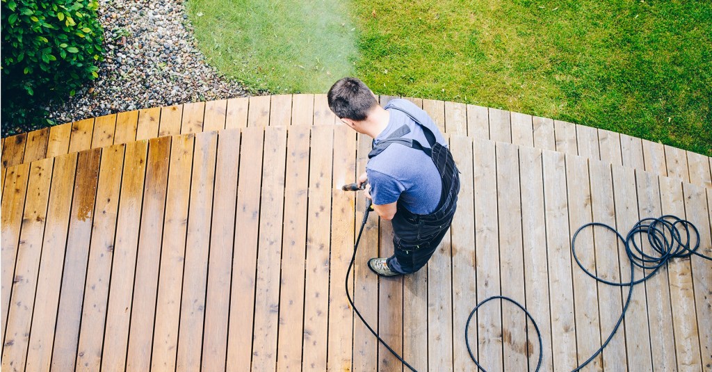 A bird's eye view of a So Clean Solutions technician cleaning a wooden deck.