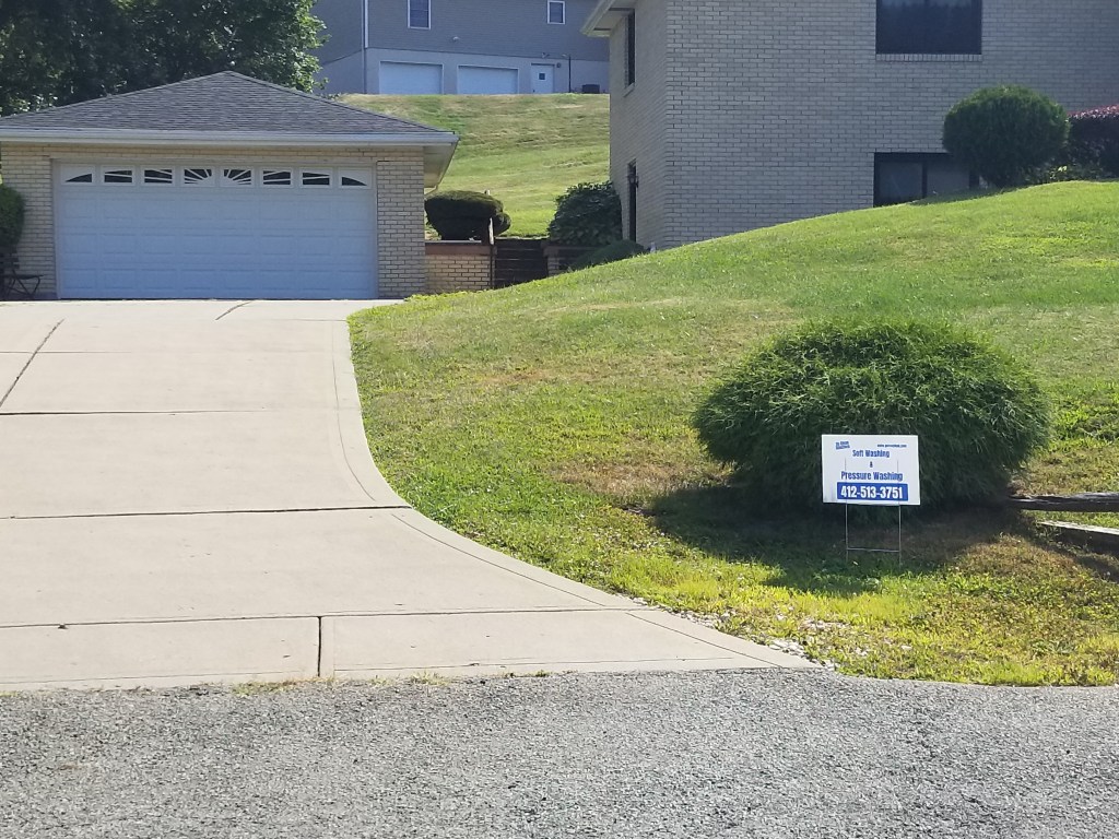 A concrete driveway on the property of a home in the Pittsburgh area that has been treated and cleaned by So Clean Solutions.