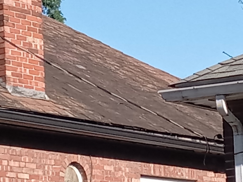A slate roof that is heavily soiled with algae growth.