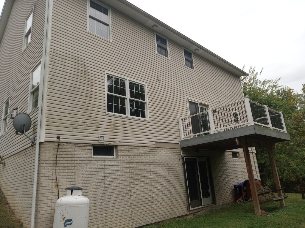 A Pittsburgh-area home with vinyl siding that is heavily soiled by algae, mold, and mildew.