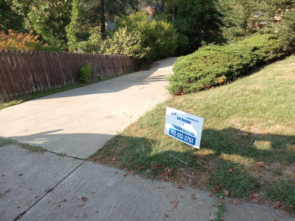 A large concrete driveway at a Pittsburgh-area home after an early summer pressure washing by So Clean Solutions.