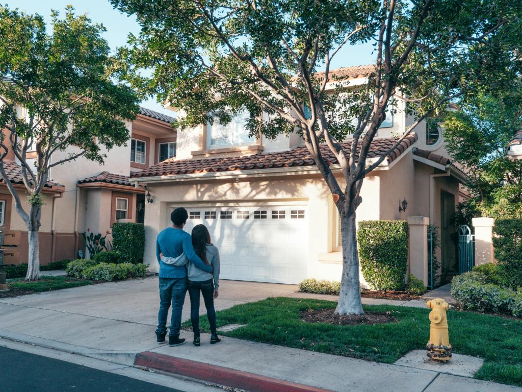 A happy couple surveys the results of a comprehensive exterior cleaning on their home.