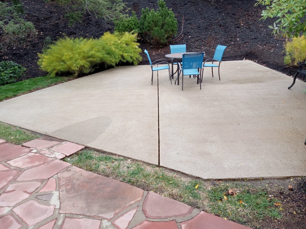 A concrete backyard patio after surface cleaning and pressure washing by So Clean Solutions.